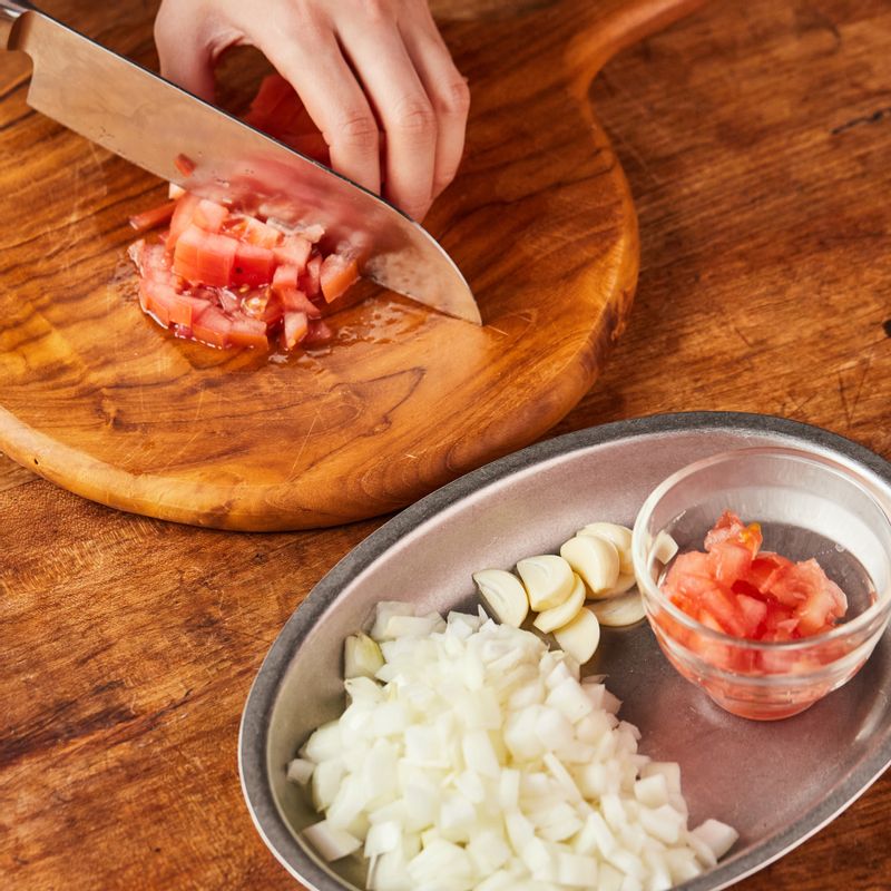 마늘은 편 썰고 양파는 깍뚝 채썰어 주세요. 자투리 채소와 소스용 토마토 1개를 썰어주세요.