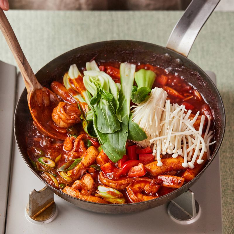 떡이 말랑말랑해지면 대파, 청경채, 팽이버섯, 파프리카를 넣은 후 참기름과 통깨를 뿌려주세요.