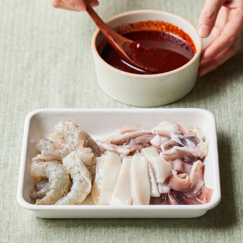 새우는 껍질과 내장을 제거해 주세요. 오징어는 먹기 좋은 크기로 잘라주세요. 볼에 양념 재료를 넣어 섞어주세요.