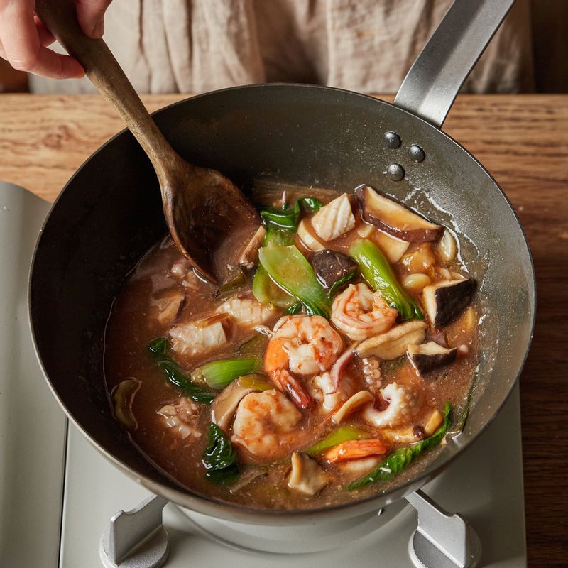 달군 팬에 기름을 두르고 파와 마늘, 생강을 넣고 볶다가 데친 채소와 간장, 청주, 굴소스와 백 후춧가루를 넣고 간을 해주세요. 해물을 넣고 2분간 볶다가 육수를 붓고 끓어오르면 불을 줄인 후 전분물 재료를 섞어 1큰술씩 넣어가며 섞어주세요. 농도가 나면 참기름을 넣어 소스를 완성해 주세요.
(tip. 해산물은 오래 볶으면 질겨지므로 짧게 볶아주세요)