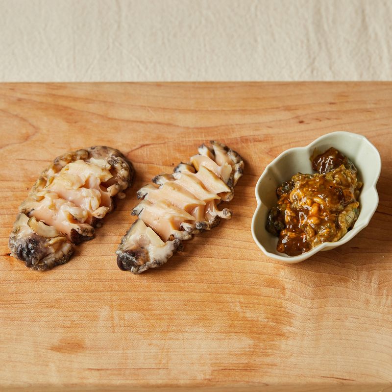 전복은 조리용 솔로 문질러 깨끗이 씻은 후 수저로 살과 내장을 떼어내어 주세요. 전복의 이빨과 모래집을 제거한 후 전복 살은 먹기 좋은 크기로 썰고, 내장은 다져주세요.