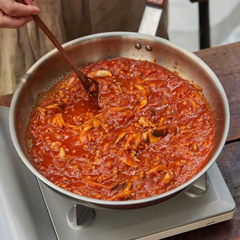 볶은 재료에 토마토소스를 넣고 뭉근하게 끓여주세요.