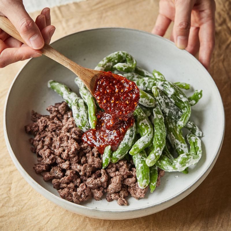 넓은 볼에 쇠고기를 넣고 손으로 잘게 부수고 꽈리고추와 양념을 넣어 가볍게 버무려주세요.