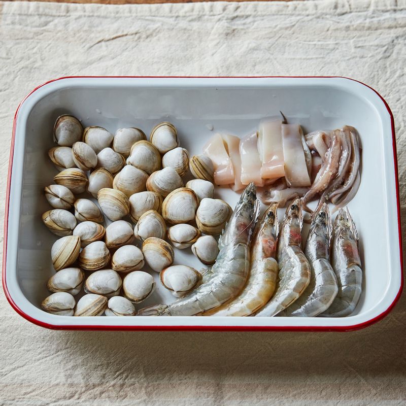 조개는 해감한 후 흐르는 물에 헹궈 준비해 주세요. 대하는 수염과 날카로운 뿔을 가위로 정리해 주세요. 오징어는 내장을 제거하고 동그란 모양을 살려 잘라주세요.