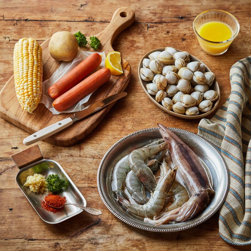 해산물 플래터을 위한 재료 이미지로 오징어,조개,대하,소시지,옥수수 등으로 구성 되어있습니다.