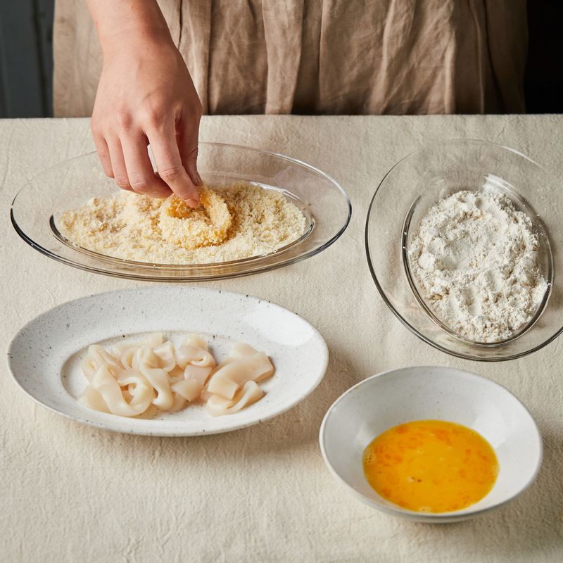 물기를 제거한 오징어에 튀김가루 - 달걀물 - 빵가루 순으로 튀김옷을 입혀 주세요.