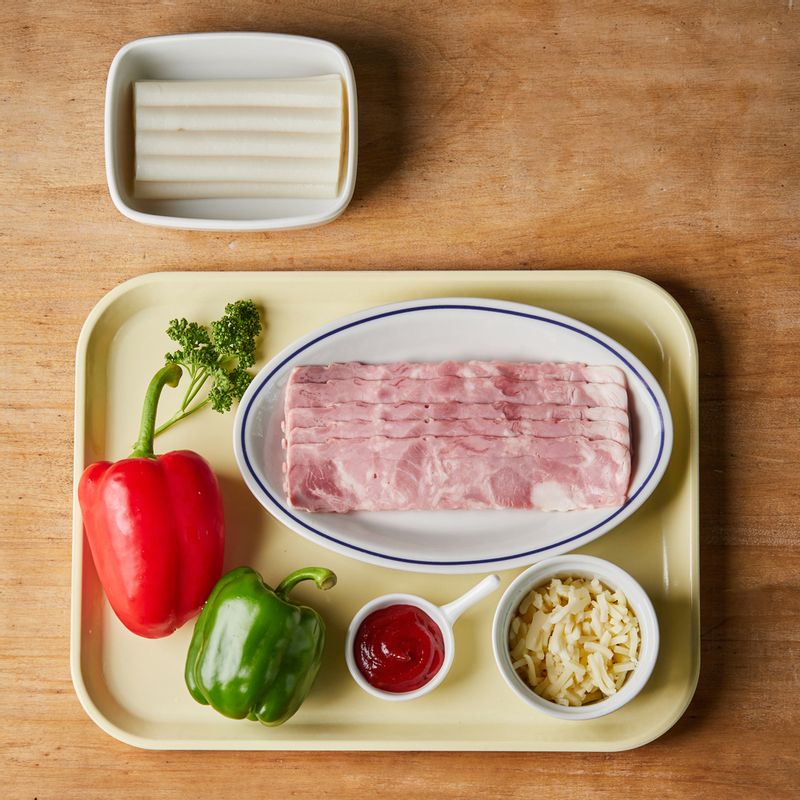 피자 베이컨 떡꼬치을 위한 재료 이미지로 떡볶이용 떡,베이컨,파프리카(초록, 빨강),모짜렐라 치즈,다진 파슬리 등으로 구성 되어있습니다.