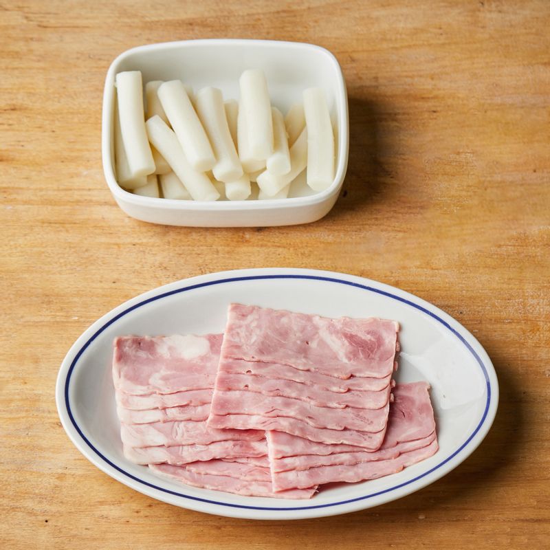 떡은 낱개로 떼어내고 베이컨은 절반으로 자르고 파프리카는 잘게 다져주세요.