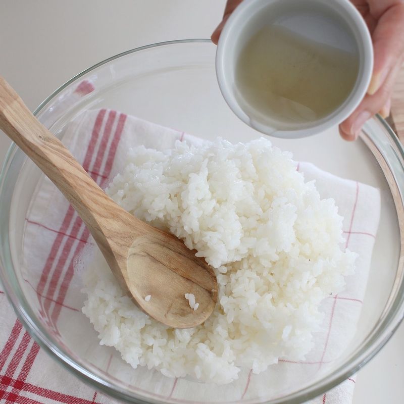 단촛물 재료를 작은 볼에 섞은 후 전자레인지에서 30초간 돌려 녹여주세요. 단촛물을 고슬고슬하게 지은 따뜻한 밥에 잘 버무려주세요.