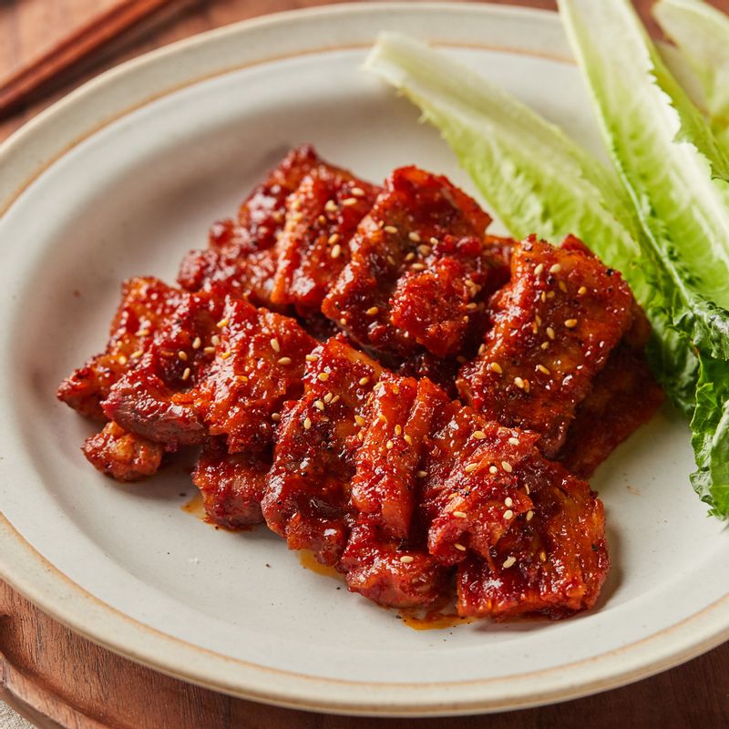 완성된 삼겹살 더덕구이를 접시에 담아 맛있게 즐겨주세요.