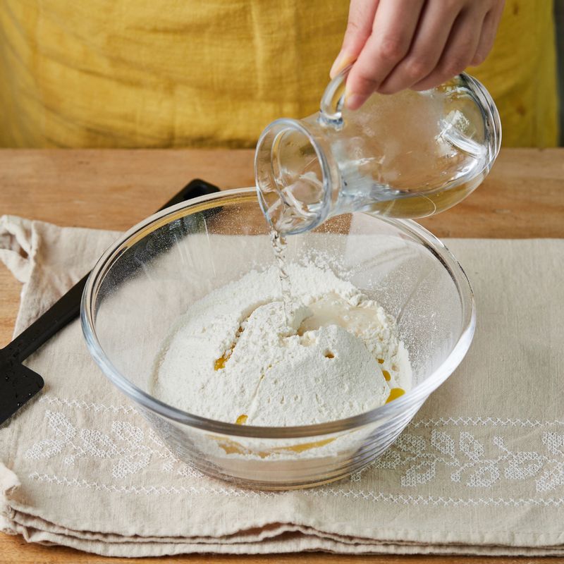 미지근한 물, 올리브유, 소금을 넣고 반죽해 주세요. 날 밀가루가 보이지 않으면 버터를 넣고 반죽해 주세요.
(tip. 반죽기가 있다면 저속으로 10분, 중속으로 10분 정도 반죽해 주세요)