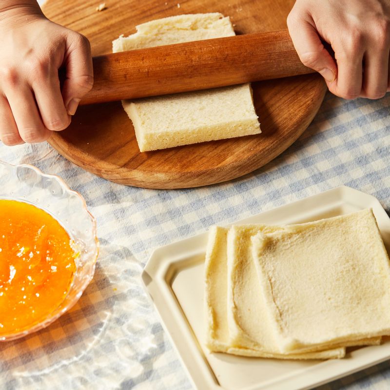 식빵은 테두리를 자르고 밀대를 이용해서 평평하게 밀은 후 한쪽 면에 귤쨈을 넣어주세요.