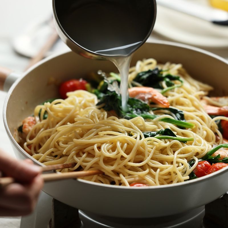 새우가 반 정도 익으면 삶아둔 면과 면수, 치킨스톡을 넣고 파마산 치즈와 레몬 제스트, 후추를 뿌려 빠르게 볶아주세요.