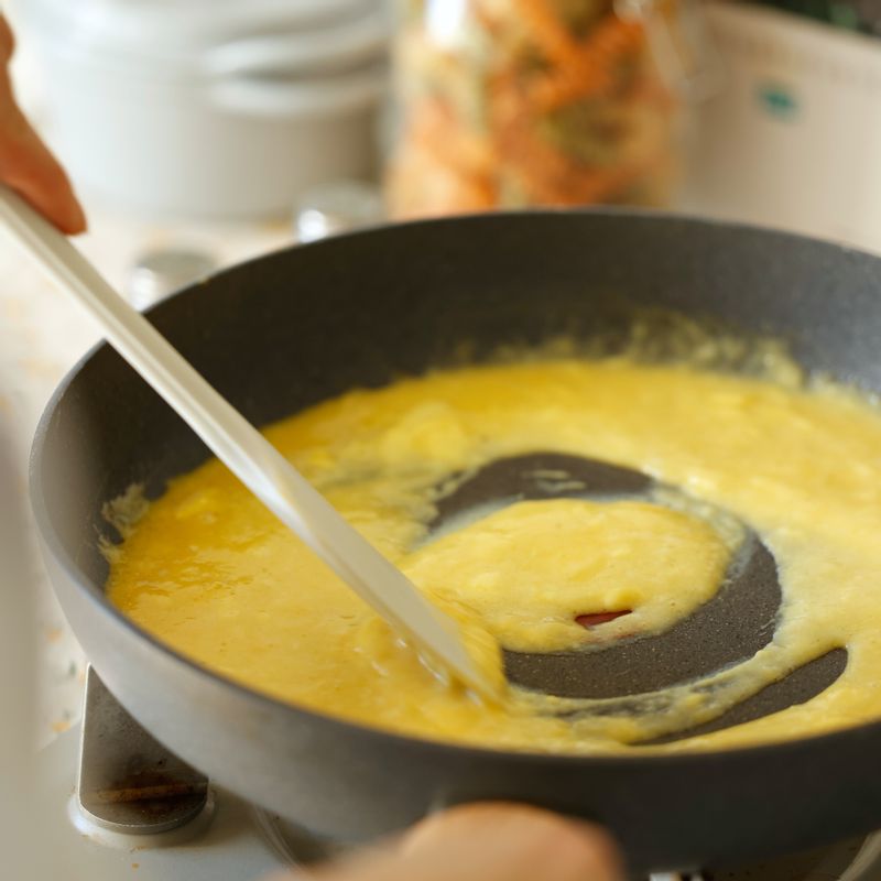 실리콘 주걱을 활용해 테두리에서 안으로 달걀을 밀어주세요. 가운데 부분에 덩어리지는 것이 보이면 한 바퀴 돌려가며 반복해 주세요.