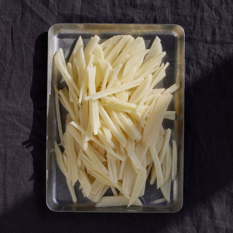 감자는 껍질을 벗기고 채칼을 이용해 3mm 정도로 채 썰어주세요. 감자가 부서지지 않도록 찬물에 살살 헹궈 전분질을 빼고 물에 5분 정도 담갔다가 체에 밭쳐 물기를 빼주세요.
(tip. 채칼을 활용하면 일정한 두께로 썰어져 균일하게 익힐 수 있어요)
(tip. 채칼을 사용할 때는 안전에 유의해 주세요)
(tip. 찬물에 헹궈 충분히 전분질을 빼야 진득하지 않게 완성돼요)