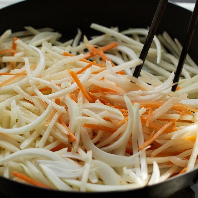 달군 팬에 기름을 넉넉히 두르고 다진 마늘을 넣고 볶아주세요. 양파, 당근, 감자를 넣어 중간불에서 볶아주세요.