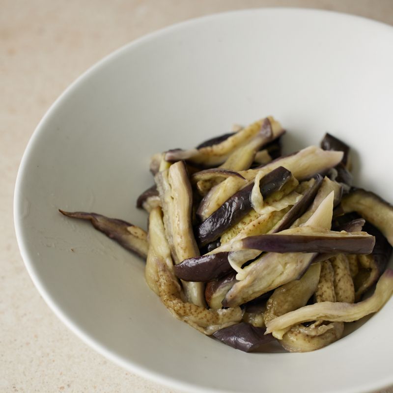 볼에 가지와 청양고추, 양념장 재료를 넣어 살살 버무려주세요. 마지막으로 참기름과 통깨를 넣어 마무리해 주세요.