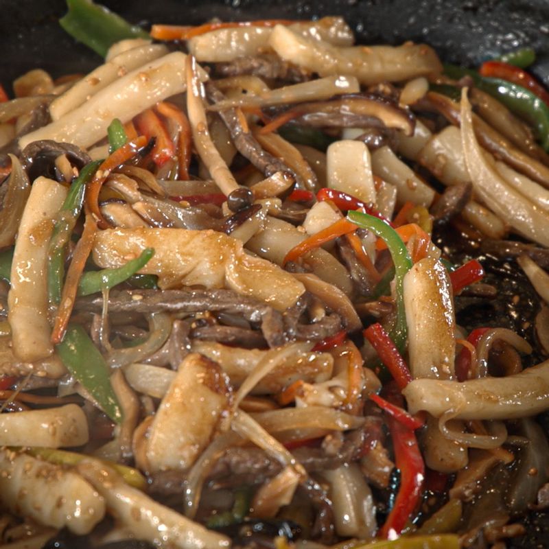 달군 팬에 데친 떡과 채소, 고기와 양념재료를 넣어 볶아주세요. 양념이 골고루 잘 배일 수 있도록 졸여주세요. 마지막으로 통깨와 참기름, 잣가루를 뿌려 맛있게 즐겨 주세요.