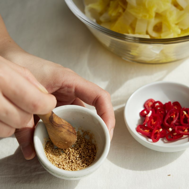 볼에 물기를 뺀 배추를 넣고 참기름과 소금을 넣고 조물조물 무쳐주세요.