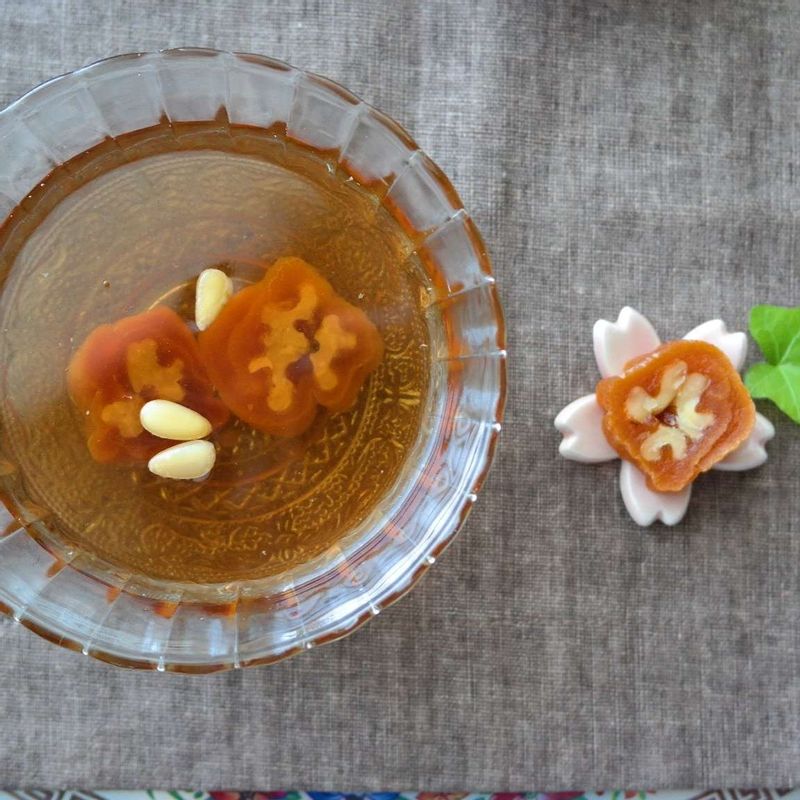 차갑게 식혀둔 수정과를 그릇에 담고 굳힌 곶감말이를 2cm 두께로 잘라 잣과 함께 띄워주세요.