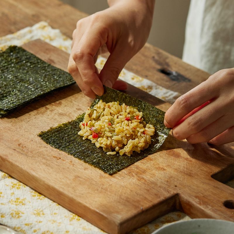 김을 4등분으로 자른 후, 김에 섞어 둔 밥을 넣고 김밥을 돌돌 말아주세요.
(tip. 밥의 끝과 김이 맞닿게 말면 더욱 예쁘게 만들 수 있어요)