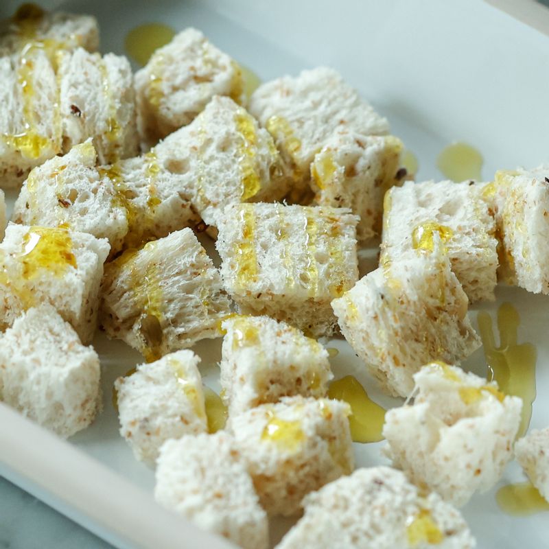 작게 썬 식빵에 올리브오일, 파르미지아노 레지아노를 뿌려 골고루 섞어주세요. 달군 팬에 식빵이 바삭할 때까지 구워내 크루통을 만들어주세요. 달군 팬에 베이컨을 바싹하게 구운 후 키친타월에 올려 기름기를 제거해 주세요.