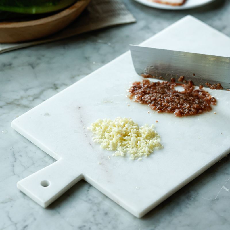 안초비와 마늘은 작게 다져주세요. 깨끗이 씻은 로메인을 반으로 썰어주세요. 식빵은 큐브 모양으로 썰고 베이컨은 먹기 좋게 썰어주세요.