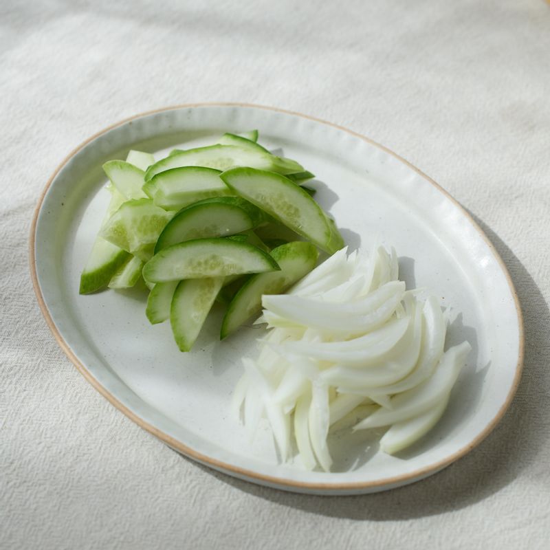 양파는 얇게 채를 썰고, 오이는 길이대로 반으로 잘라 어슷하게 썰어주세요.