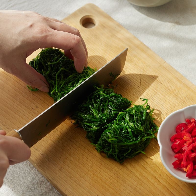물기를 꽉 짠 후 먹기 좋은 크기로 잘라주세요. 홍고추는 반으로 갈라 씨를 제거한 후 송송 썰어주세요.