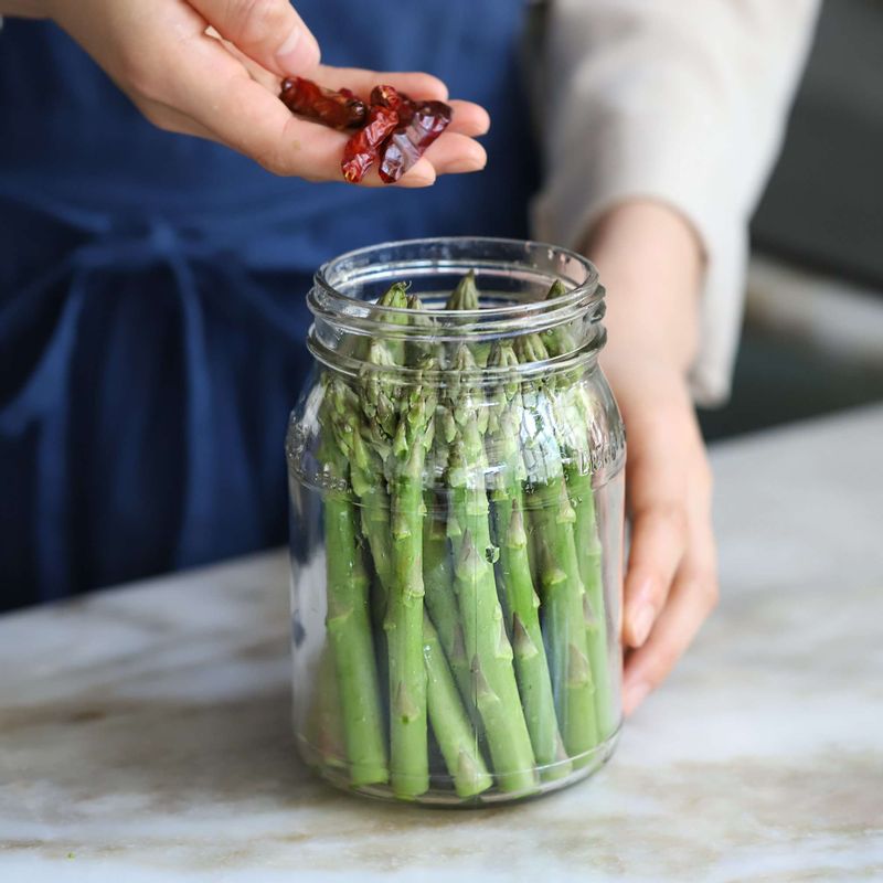 소독한 유리병에 아스파라거스와 홍고추를 담아주세요.