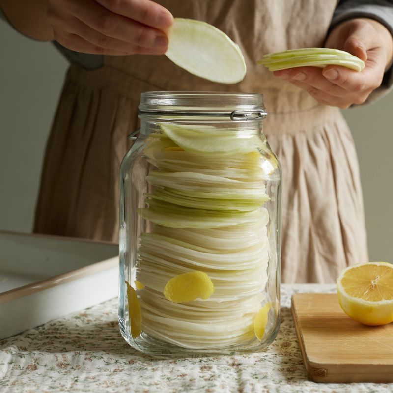 무를 내열 가능한 밀폐용기에 담고 끓인 절임 물을 부어주세요.