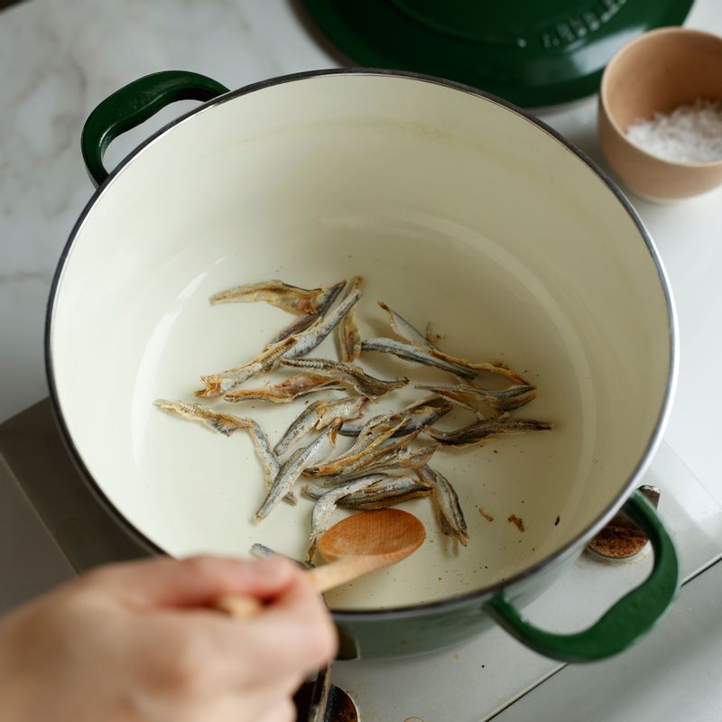 팬에 손질한 멸치를 넣고 약불에서 볶다가 고구마순과 멸치 다시다물을 넣고 섞어둔 양념장을 넣은 후 중약불에서 볶아주세요.