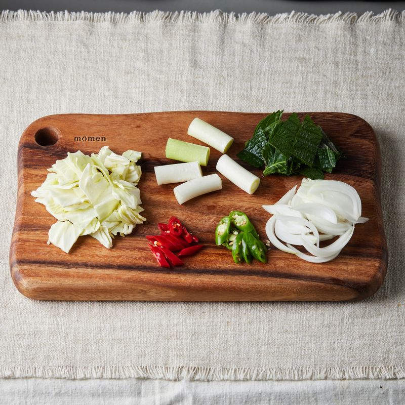 대파는 4cm 길이로 자르고, 양파는 굵게 채를 썰어주세요. 양배추와 깻잎은 먹기 좋은 크기로 자르고, 청홍고추는 어슷하게 썰어주세요.