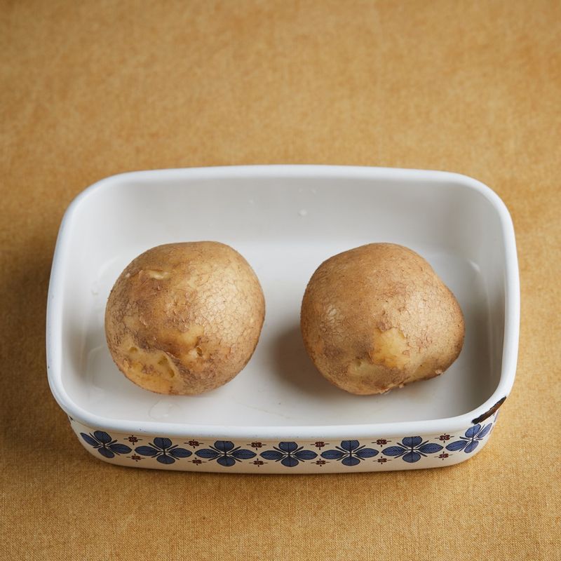 깨끗이 씻은 감자를 내열 용기에 담고 랩을 씌워주세요. 법랑 접시에 석쇠를 놓고 내열 용기를 올려 1단에 넣고 광파오븐 수동요리 <스팀 레인지>에서 5분간 익혀주세요. *물을 채운 물통을 제품에 설치해서 요리하세요.