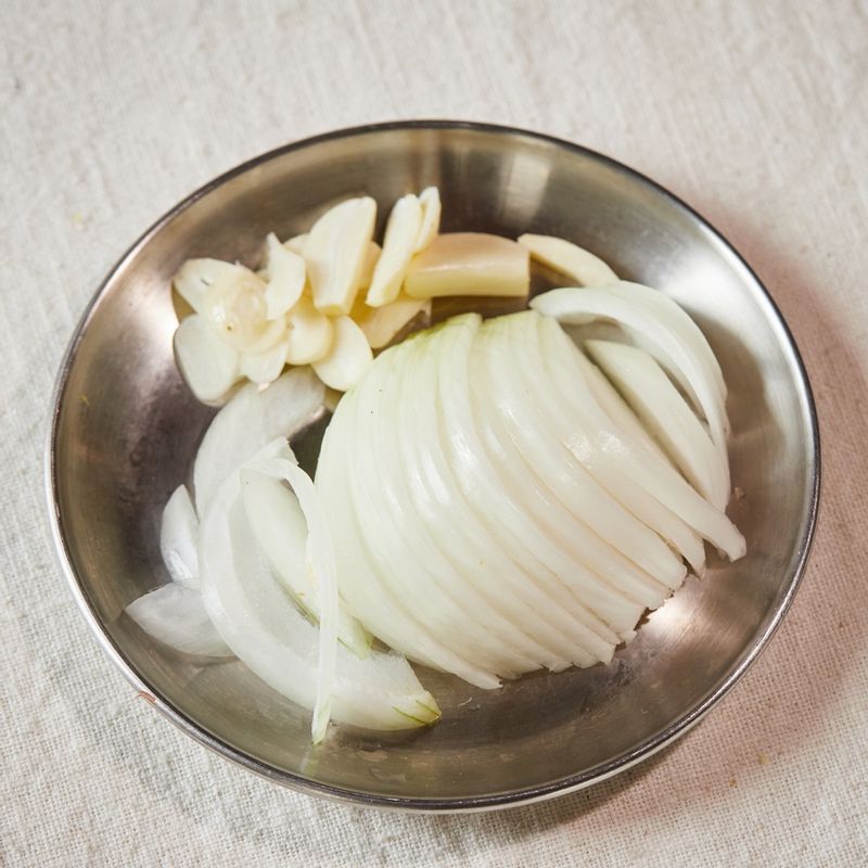 마늘은 편 썰고 양파는 채 썰어주세요. 레몬 껍질은 제스트를 내고 반으로 갈라 즙을 짜주세요.