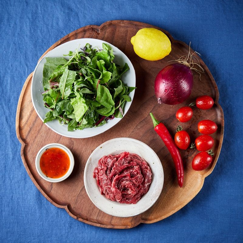 태국식 불고기 샐러드을 위한 재료 이미지로 쇠고기(불고기용),방울토마토,적양파,샐러드 채소,홍고추 등으로 구성 되어있습니다.