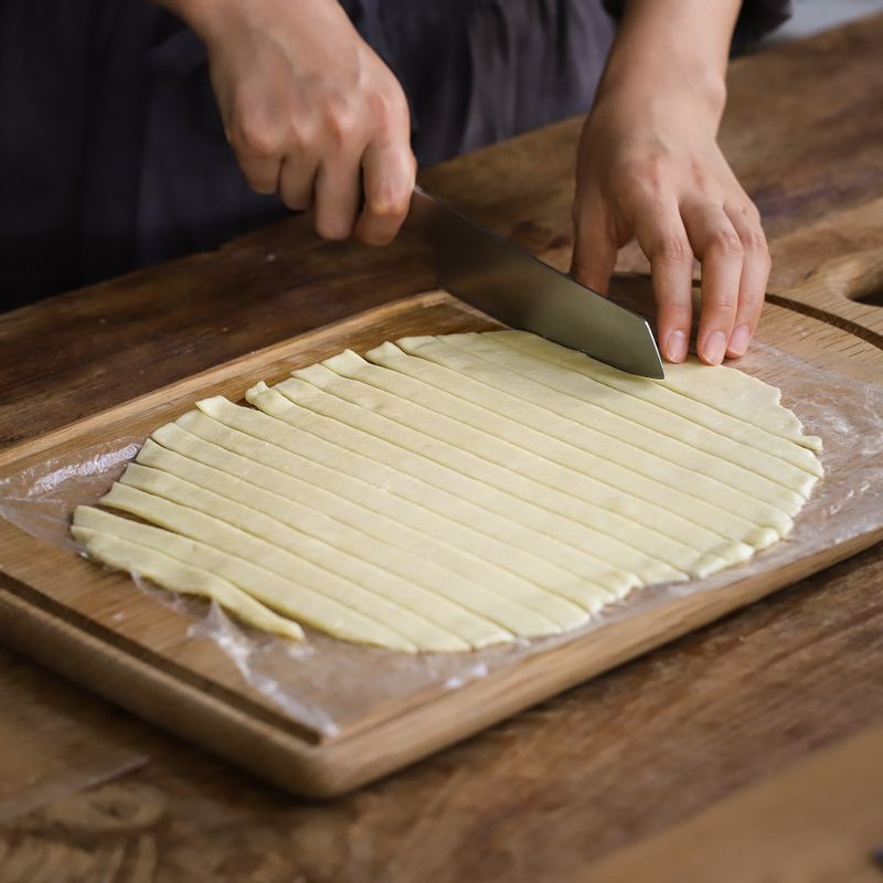 휴지시켜 둔 뚜껑용 반죽의 아래위에 비닐을 깔고 중간중간 비닐에 반죽이 붙지 않도록 양면에 덧밀가루를 뿌려가며 0.2cm가 되도록 밀대로 밀어주세요.
반죽을 1cm 넓이로 길게 잘라 파이틀 가장자리를 꼭꼭 눌러가며 격자무늬로 붙여주세요.