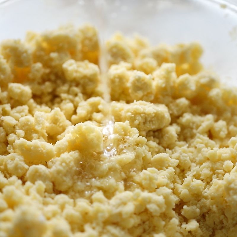 반죽이 부슬부슬한 상태가 되면 찬물과 달걀노른자를 넣고 주걱으로 자르듯이 돌려가며 섞어주세요.