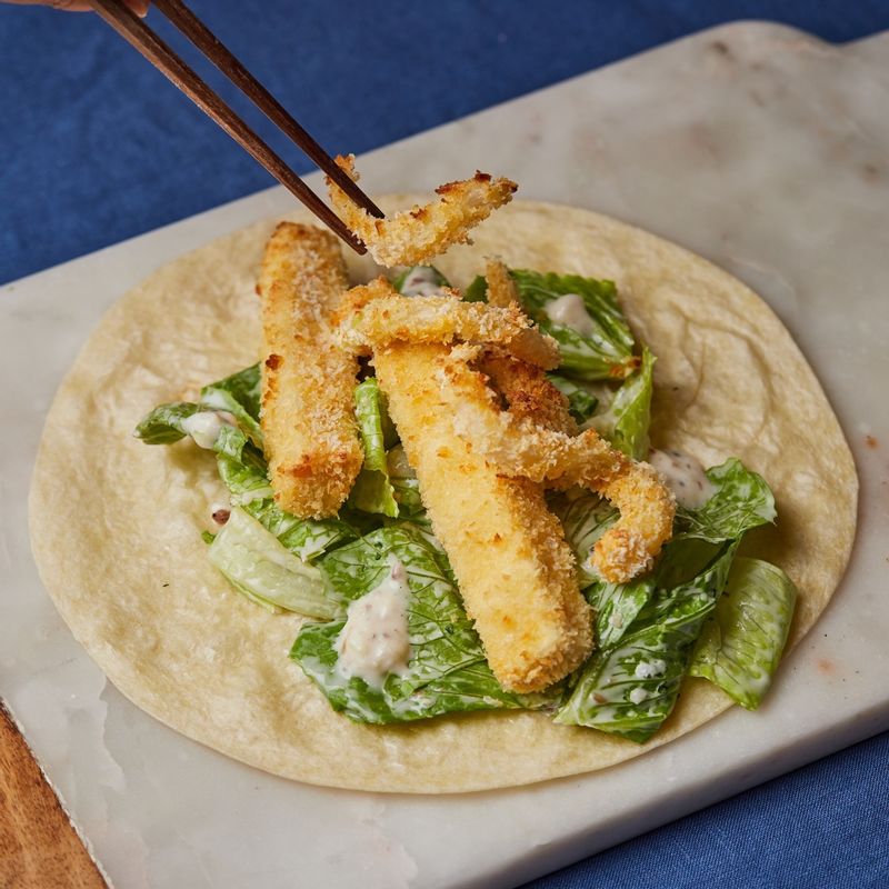 또띠아에 소스에 버무린 로메인과 튀긴 두부, 양파를 넣고 돌돌 말아주세요.