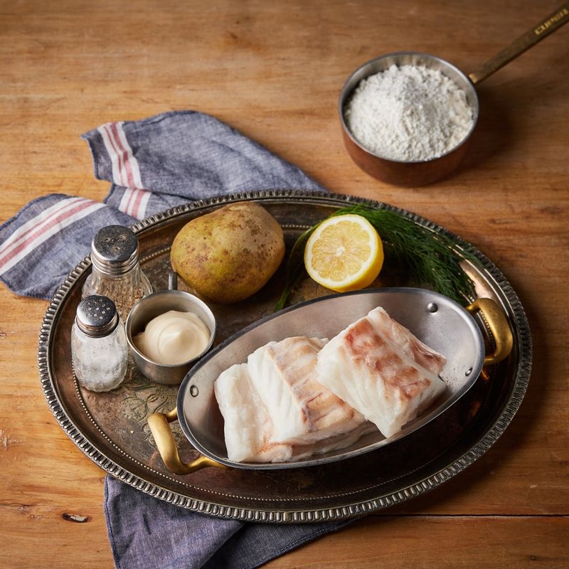 피쉬앤칩스을 위한 재료 이미지로 대구살,감자,레몬,식용유,소금 등으로 구성 되어있습니다.