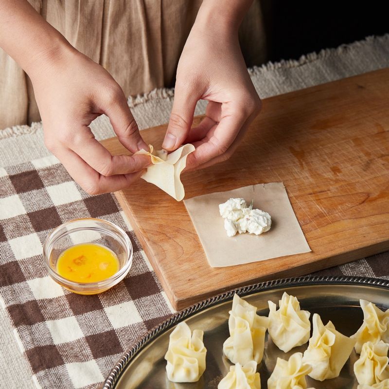 춘권피에 섞어둔 속재료를 넣고 가장자리에 달걀물을 바르고 오므려주세요.