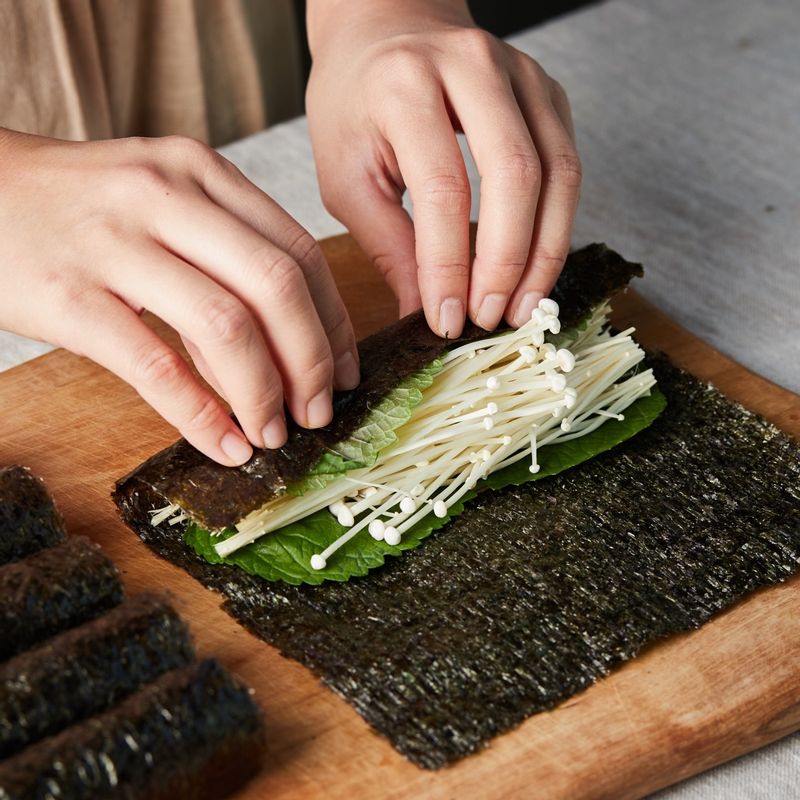 김위에 어묵을 올리고 쪽파를 넣고 돌돌 말고 깻잎과 팽이버섯을 올려 돌돌 말아 준비해 주세요.