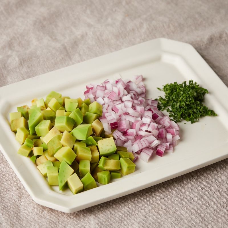 아보카도는 사방 1센치 크기로 잘라주세요. 적양파는 사방 0.5센치 크기로 자르고, 파슬리는 잘게 다져주세요.