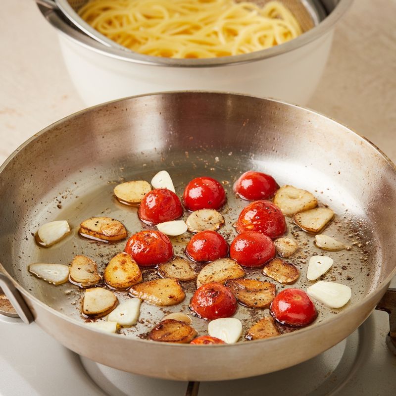 팬에 올리브오일을 두르고 편썬 마늘을 볶다가 방울토마토를 넣고 소금과 후춧가루로 밑간하여 볶아주세요.