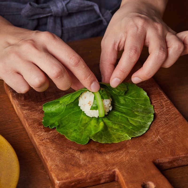 케일에 밥을 넣고 돌돌 말아주세요. 
(tip. 케일잎이 작으면 2겹 겹쳐서 사용해도 좋아요) 
(tip. 케일의 줄기부분을 얇게 썰어내면 말기 편리해요)