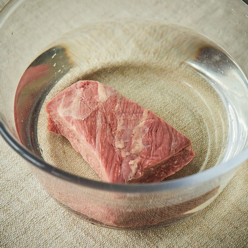 쇠고기 양지를 찬물에 담가 30분 정도 핏물을 빼주세요. 고기가 잠길 정도의 물과 고기 삶는 재료를 냄비에 넣고, 물이 끓어오르면 고기를 넣어 1시간 정도 삶아주세요.