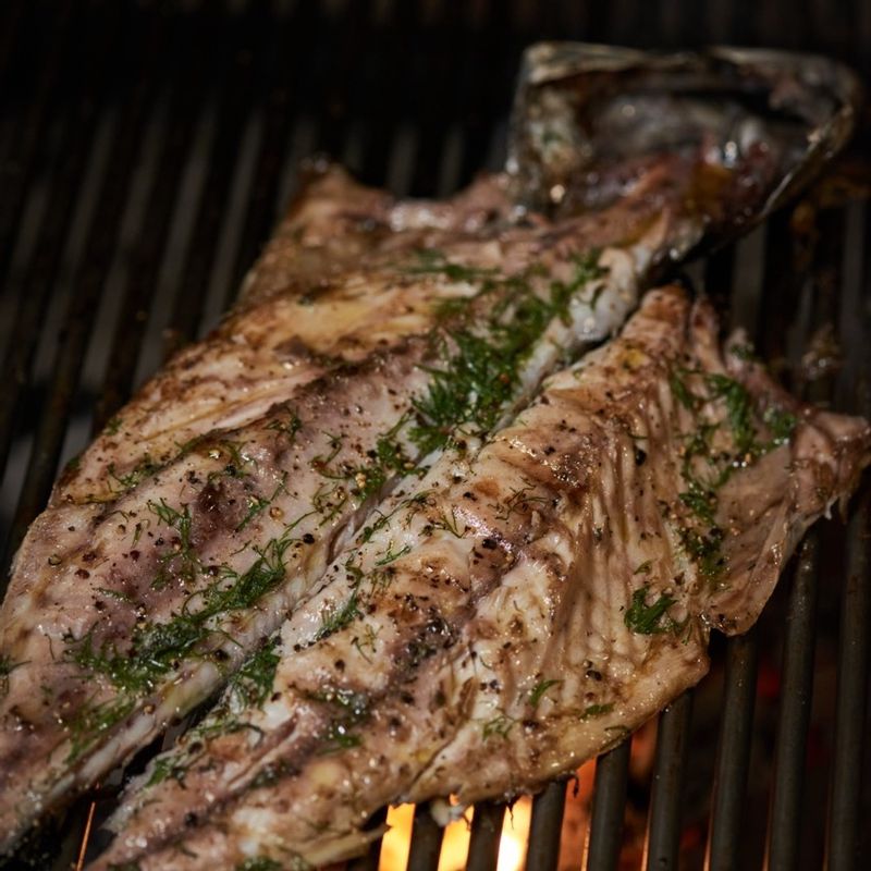 간고등어 위에 딜과 후춧가루를 뿌린 후 숯불에서 13분 동안 구워 주세요.