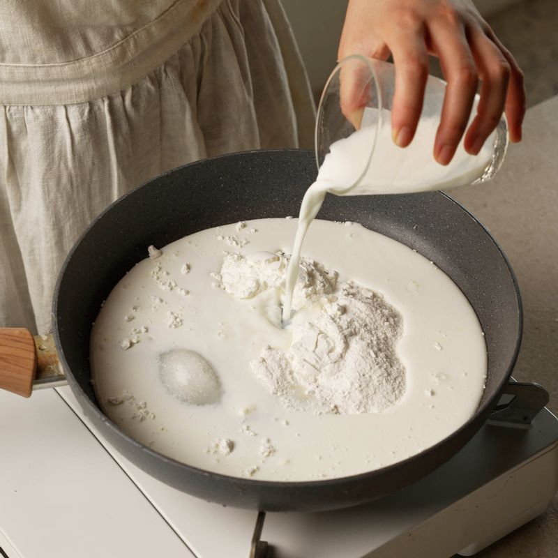 팬에 찹쌀가루, 옥수수 전분, 설탕, 소금, 우유를 넣고 잘 섞어주세요. 반죽이 뭉쳐질 때까지 약불에서 저어가며 데워주세요.
(tip. 우유를 저어주면 조금씩 덩어리지기 시작하고 곧 한 덩어리로 뭉쳐진답니다)