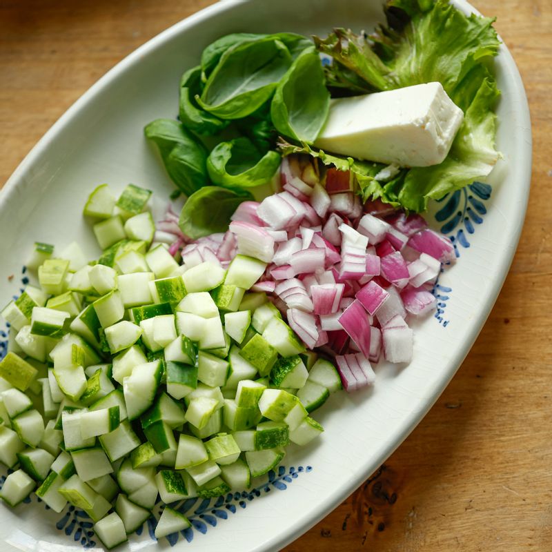 오이는 모양대로 4등분 하고 씨를 제거한 후 작은 큐브 모양으로 썰어주세요. 토마토와 적양파도 같은 크기로 썰어주세요.
