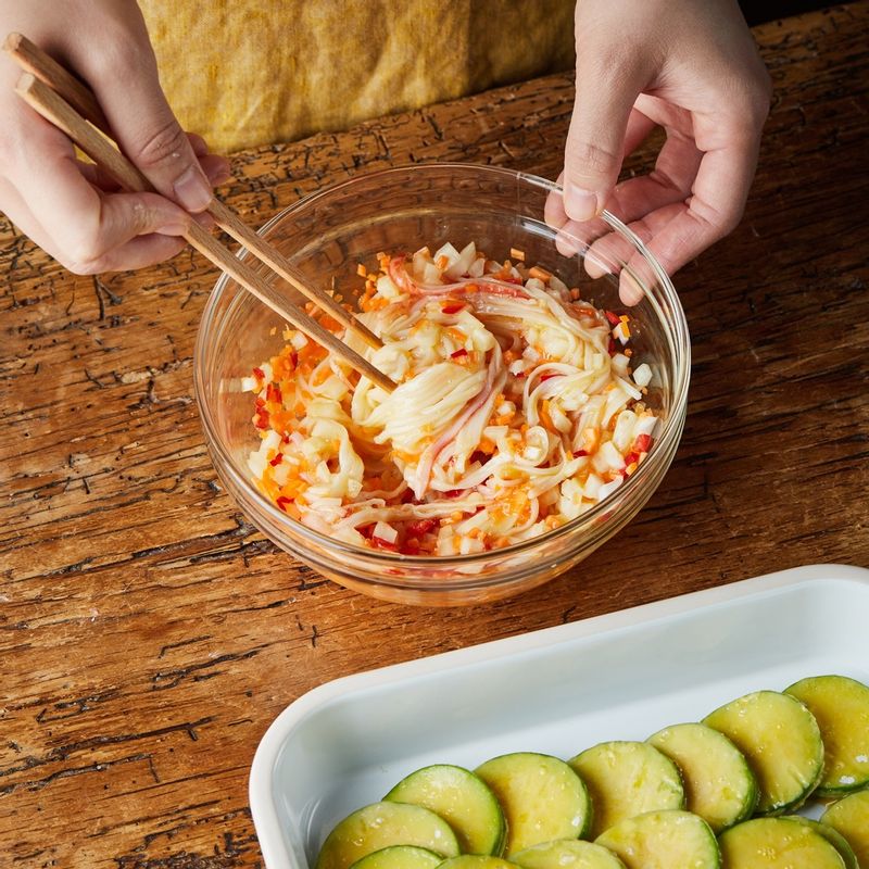 남은 달걀물에 맛살과 다진 채소를 넣고 섞어 소를 준비해 애호박에 넣어주세요.